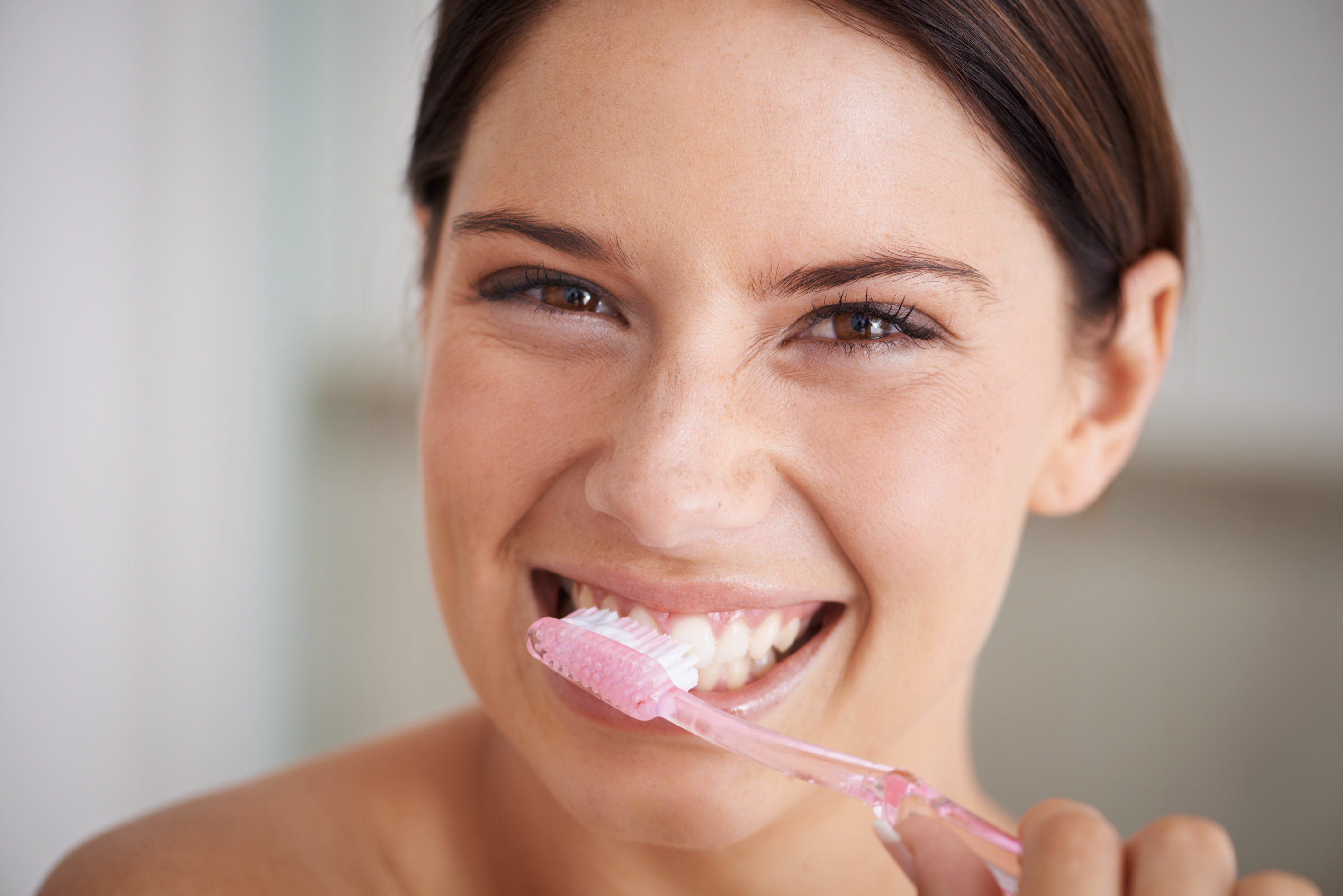 A gorgeous young brunette brushing her teeth in the morning